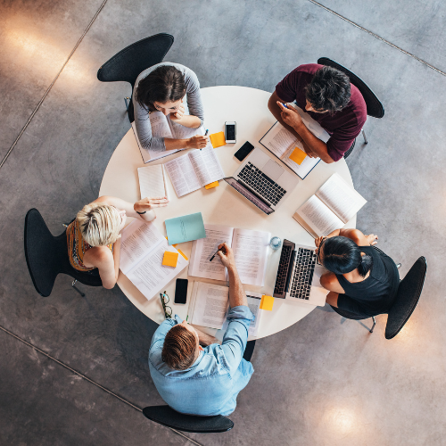 Group of students studying at a round table.