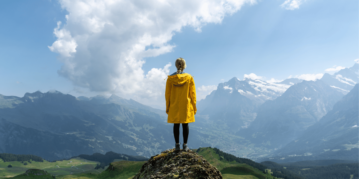 Peron standing on top of a mountain in another country.