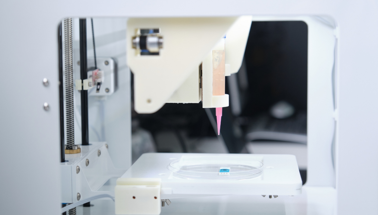 Close-up of a 3D bioprinter depositing bio-ink into a petri dish