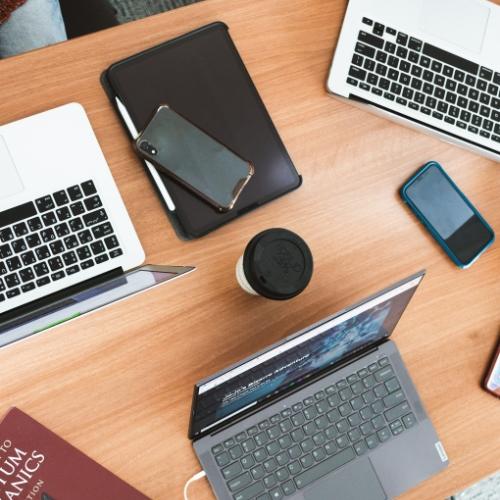 Aerial view of laptops on a table.
