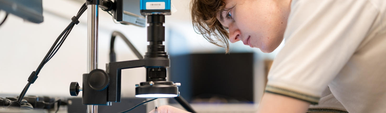Student placing object under microscope.