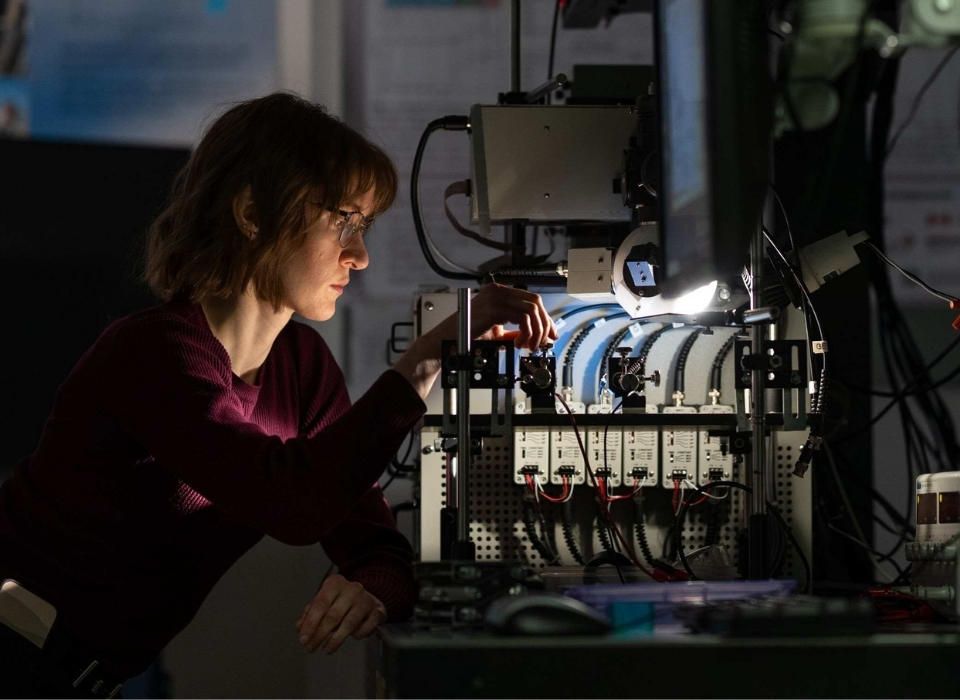 Student conducting photonics research in lab.