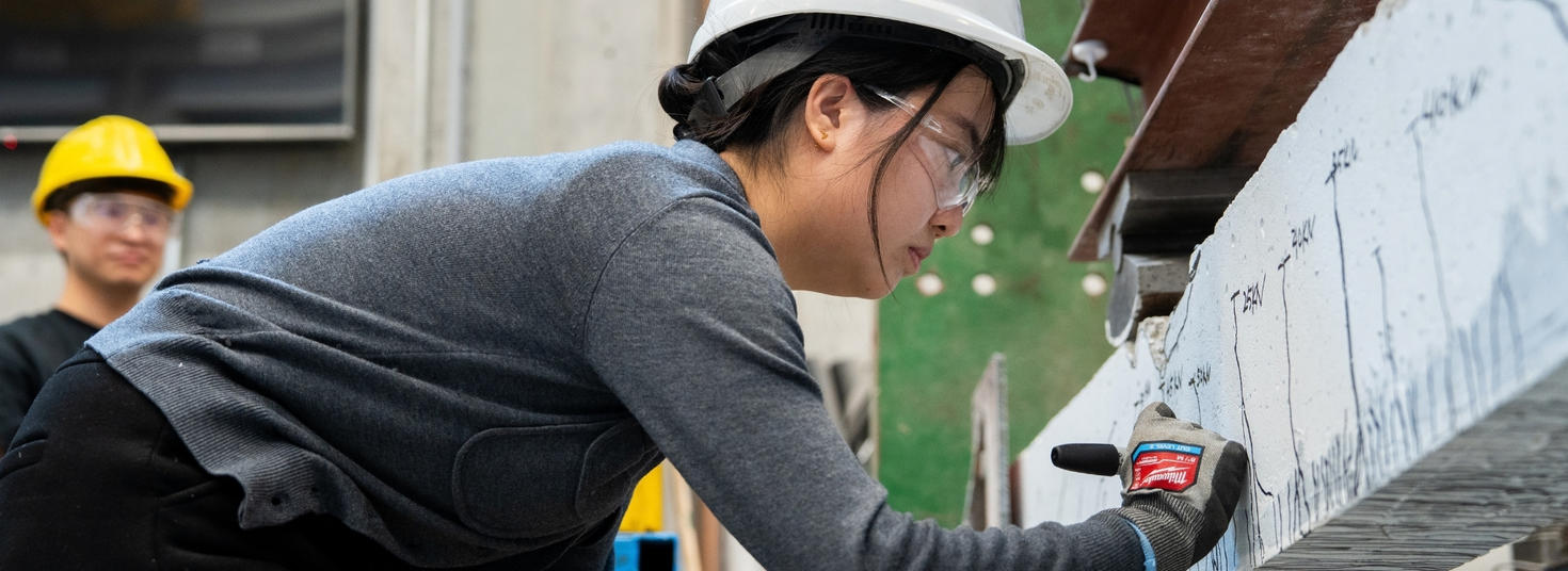 Student marking a concrete bloc in a civil engineering lab.