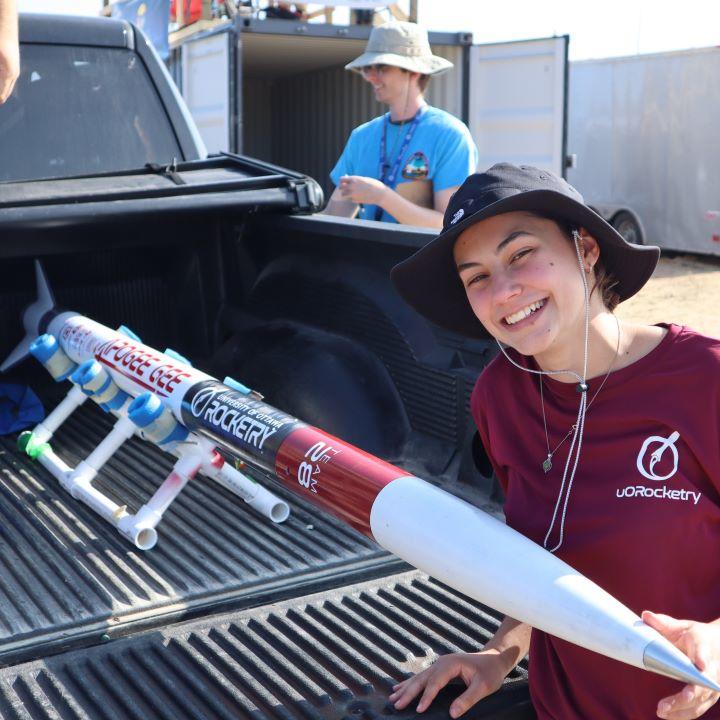 Éloïse Plante Sabourin next to the Perigee-Gee rocket, which is in the back of a pickup truck.