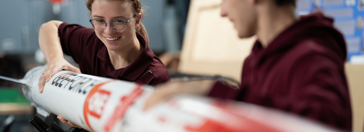 Two students putting together a rocket.