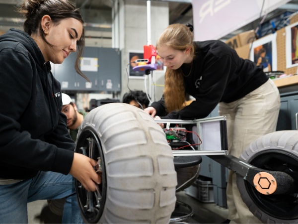 Two students working on a rover.
