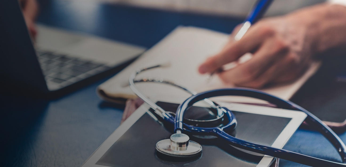 A nurse writing on a pad of paper