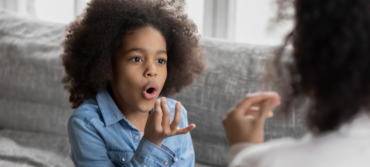 A child is practicing with a speech therapist