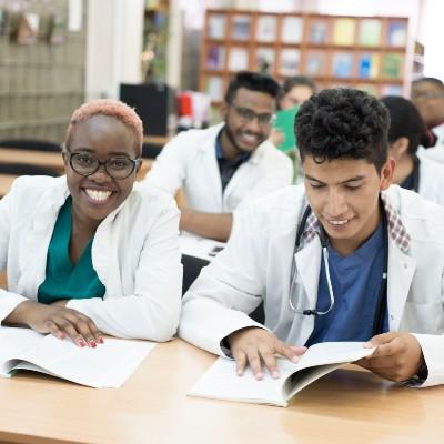 A group of nursing students sit at desks in a classroom