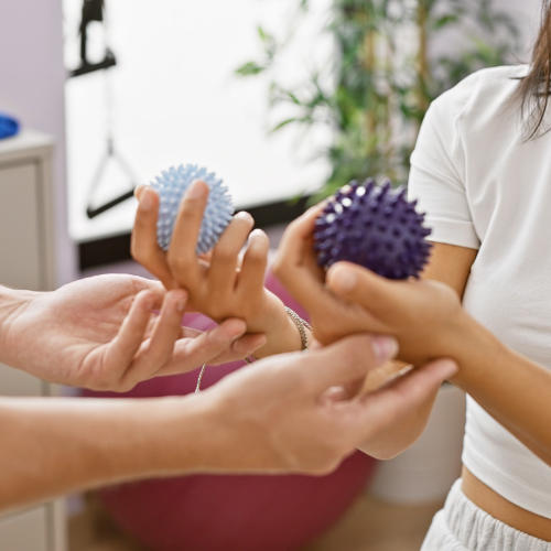 a therapist helping a woman manipulate two balls
