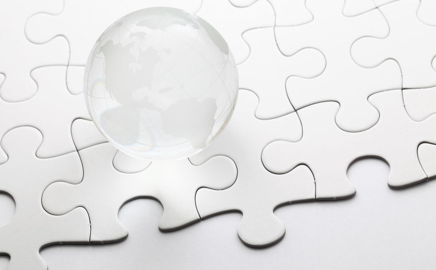 A globe rests on a puzzle