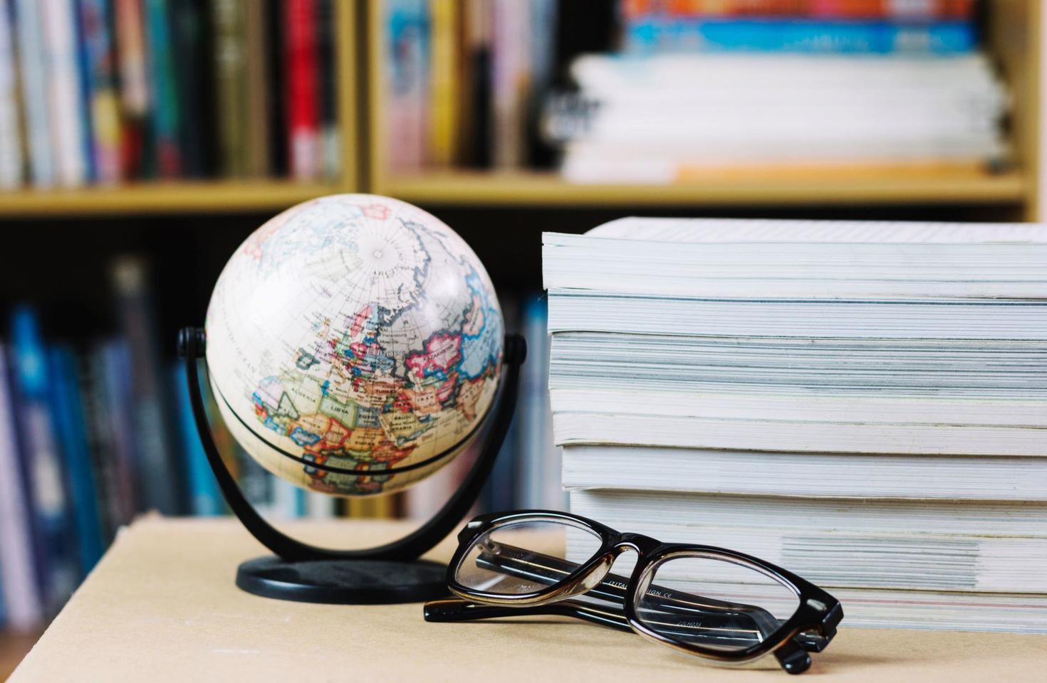 Globe, glasses and books on the desk