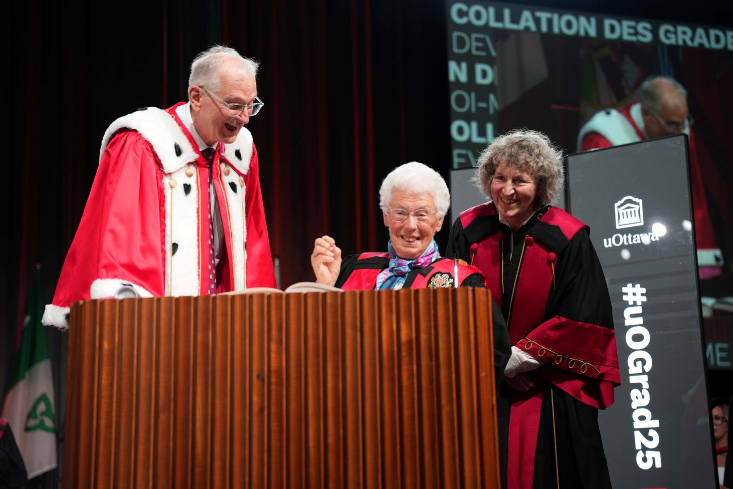 Ms. Abby Hoffman signing her honorary doctorate with President and Vice-Chancellor Jacques Frémont and Dean Lucie Thibault.