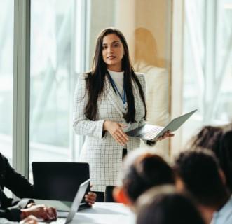 woman leading a business meeting holding a laptop