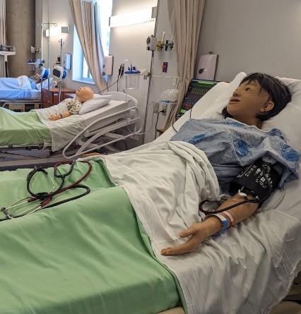 Simulation manikin on a hospital bed