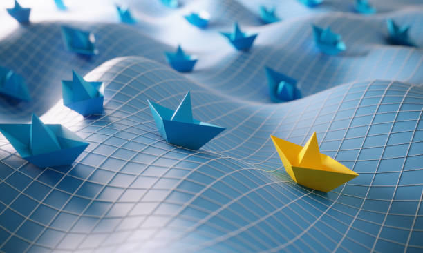 Origami paper boats glide across a rolling, grid-patterned  surface that  resembles an abstract ocean