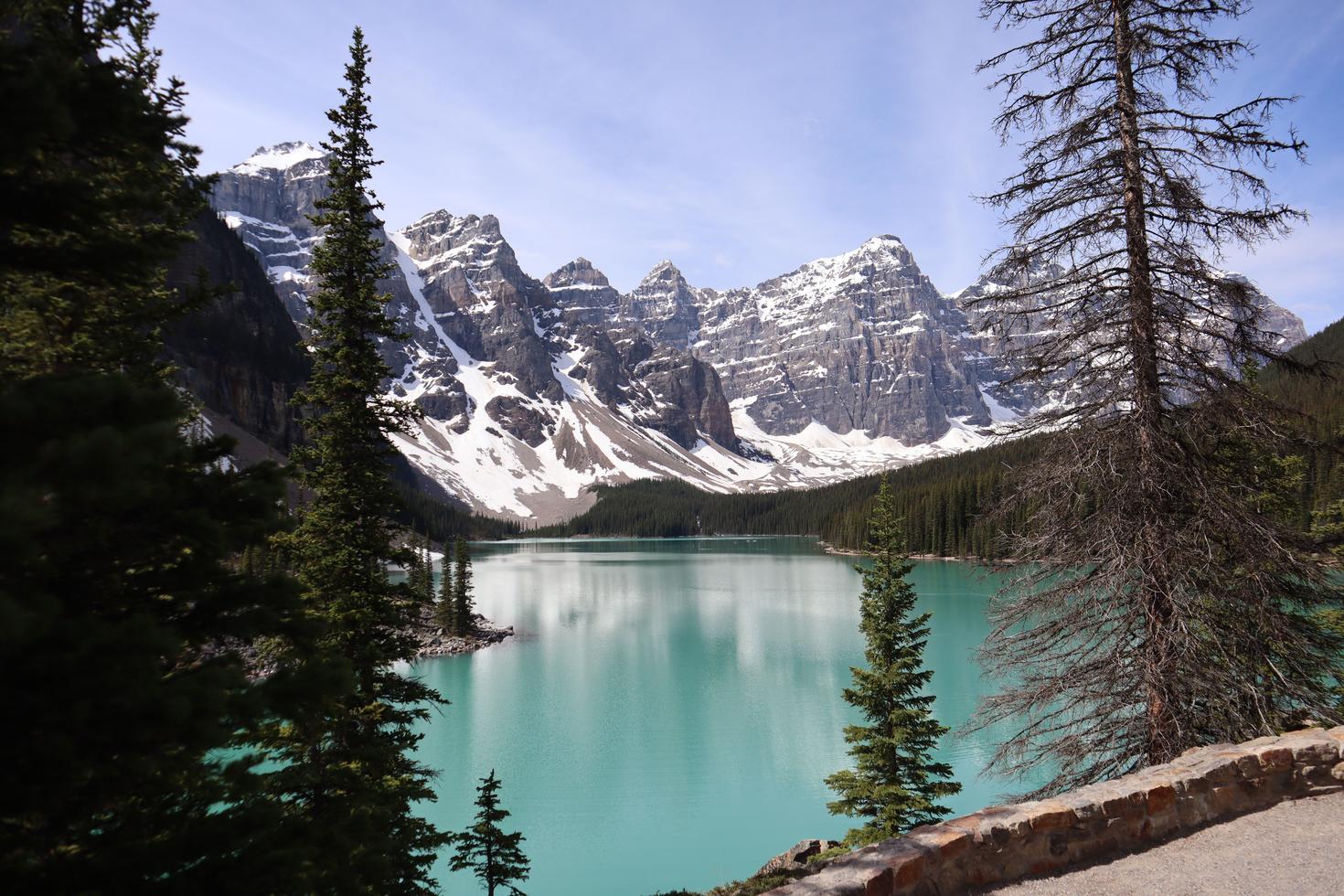 Snow-capped mountains rise above a turquoise lake