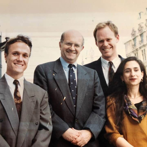 Four people stand facing the camera and smiling