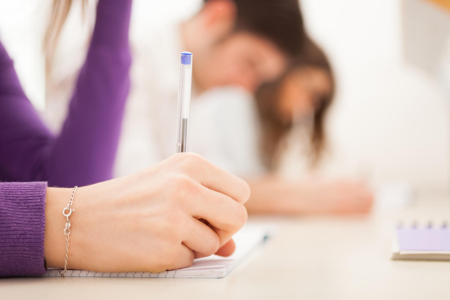 Student writing with a pen