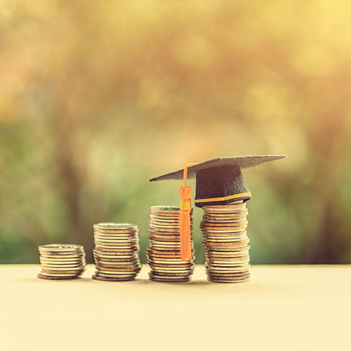 Pile of money with graduation hat