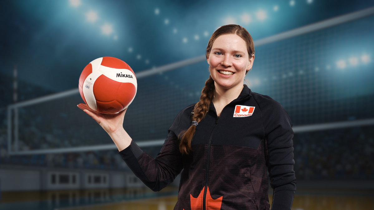 Annie Fergusson holds a volleyball in her right hand, she is smiling