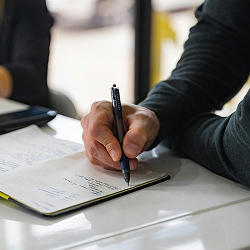 Person writing in book