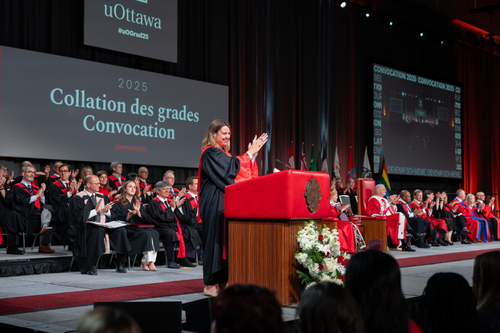 The dean Kristen Boon clapping on stage. 