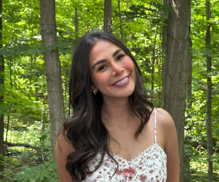 Young woman posed in front of trees