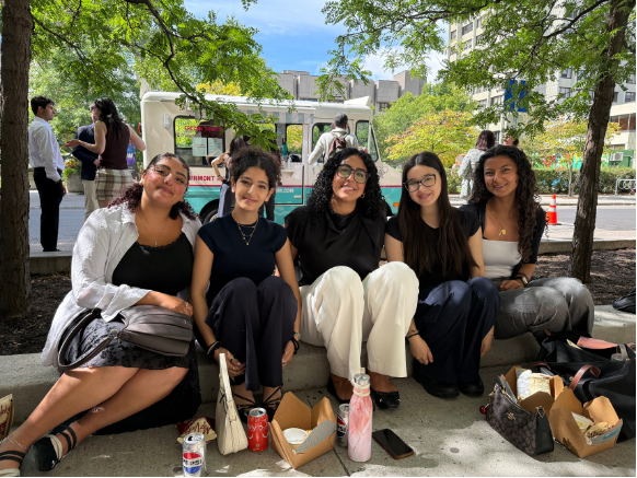 Image of 5 female students sitting on the ground