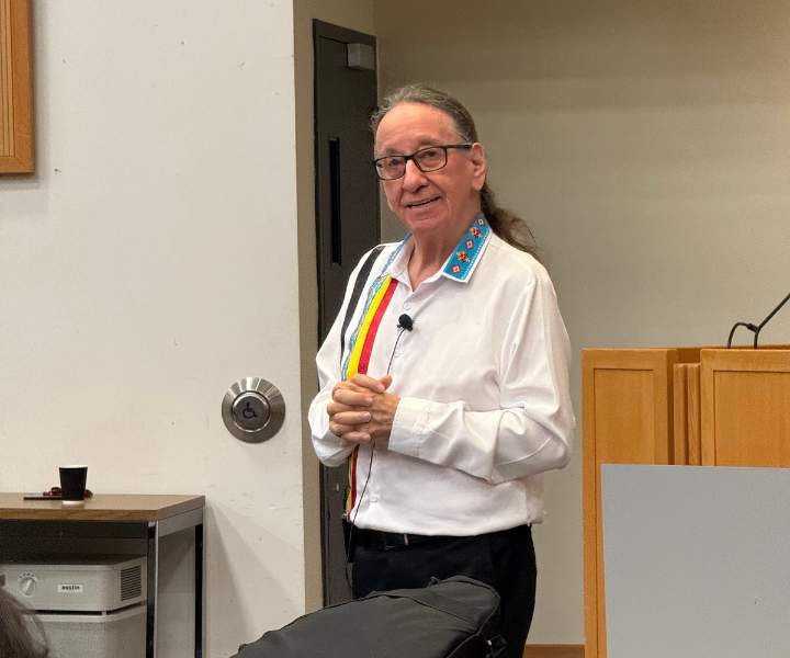 Image of a man speaking in front of a podium