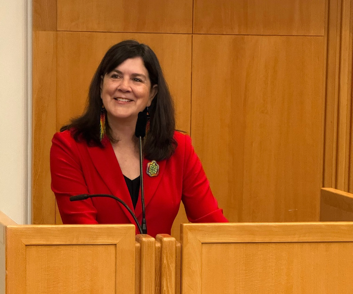 Image of a a female judge speaking behind a podium
