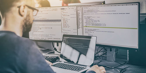 Man sitting at a computer with two screens