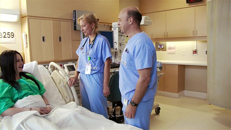 Doctors talking to a patient in hospital ward