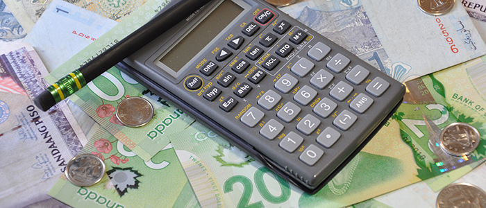 Essential payroll tools: a calculator, a pencil, and currency. 
