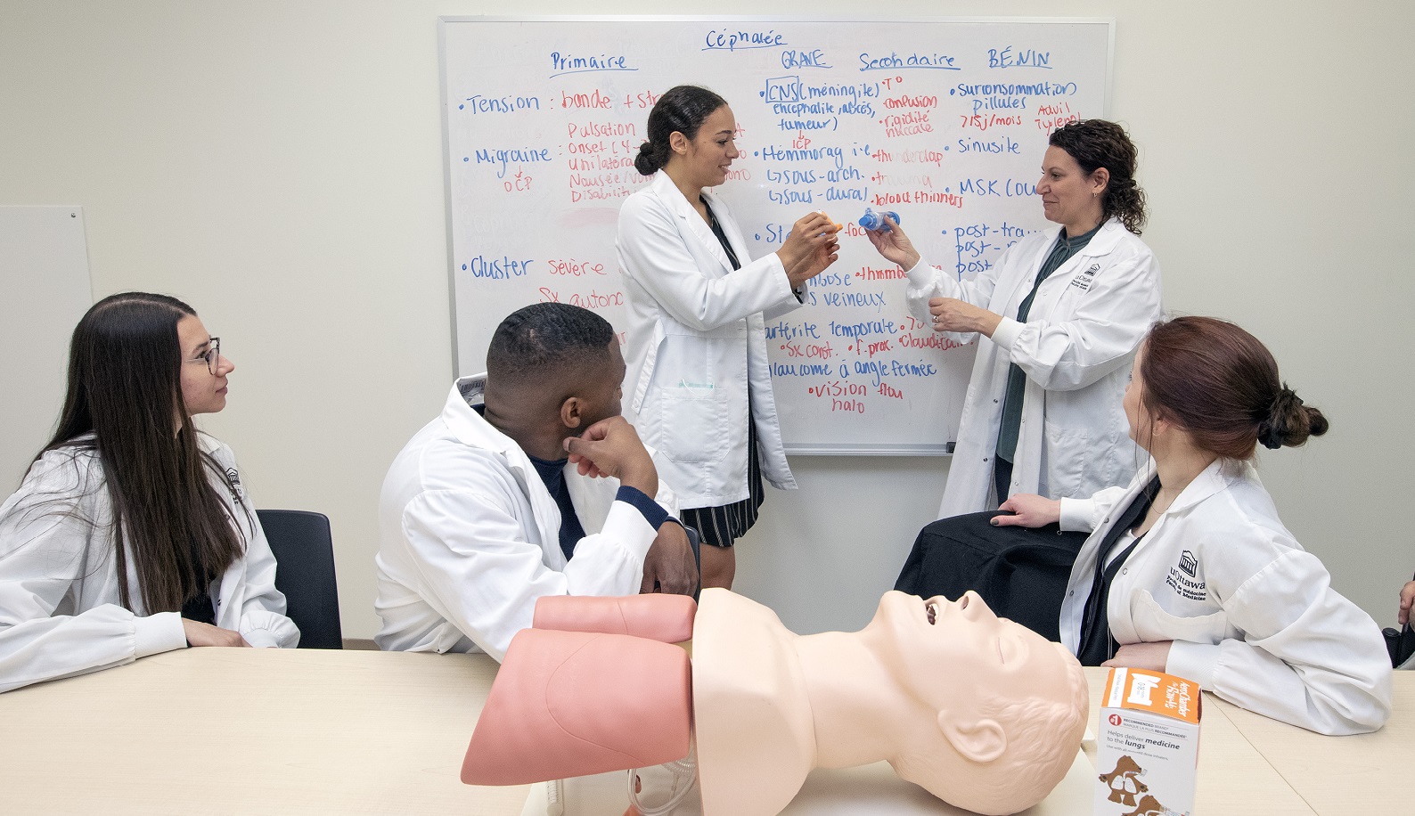 Group of pharmacy students and their teacher practicing a technique