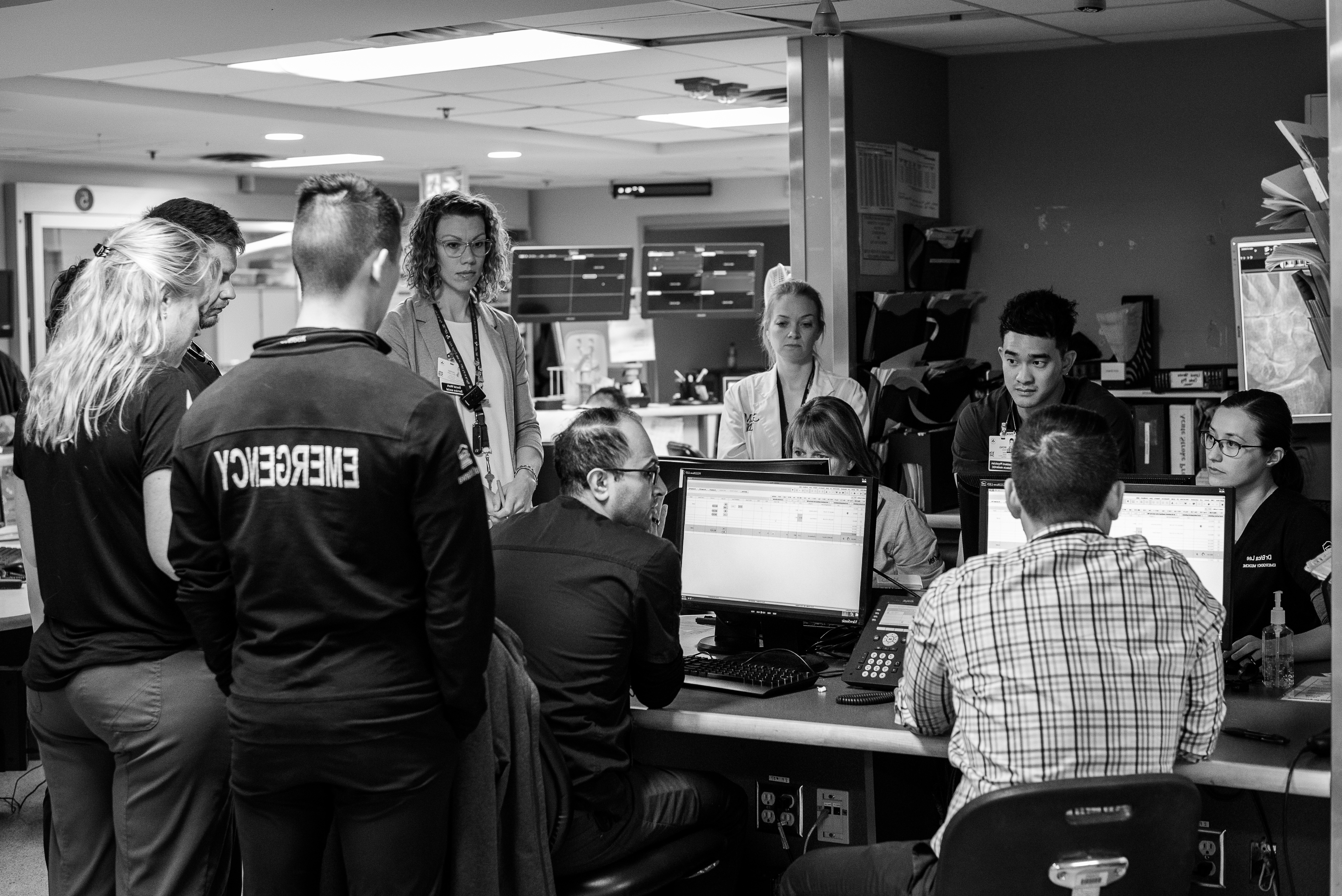 Group of doctors around computer screens debriefing