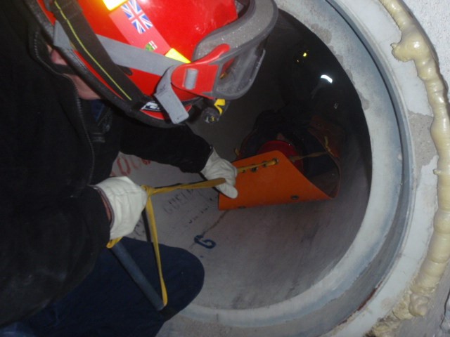 Paramedic pulling patient on stretcher out of a cement cylinder