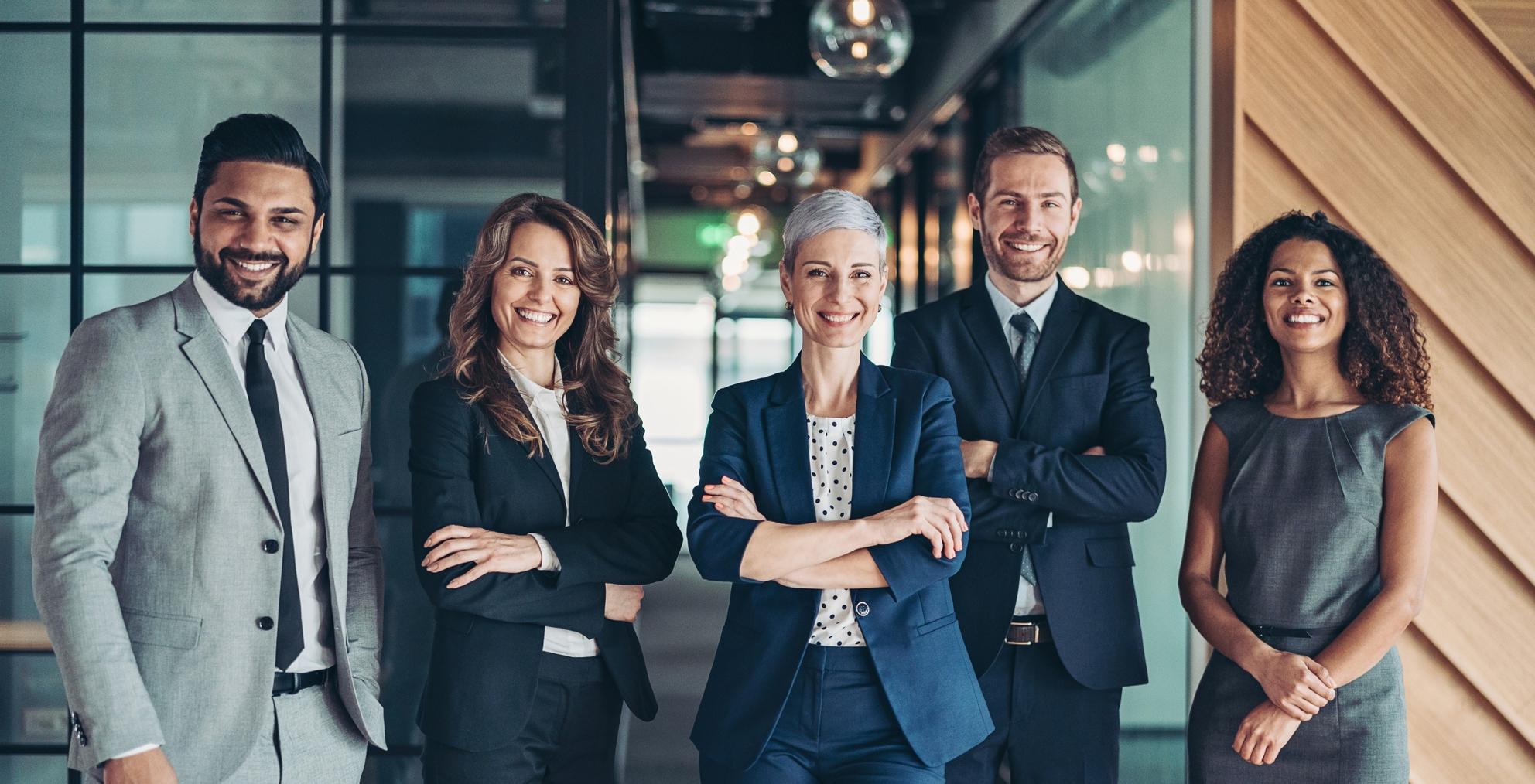 Group of professionals standing together in a modern office environment.