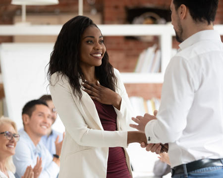 a woman and a man in professional attire shaking hands