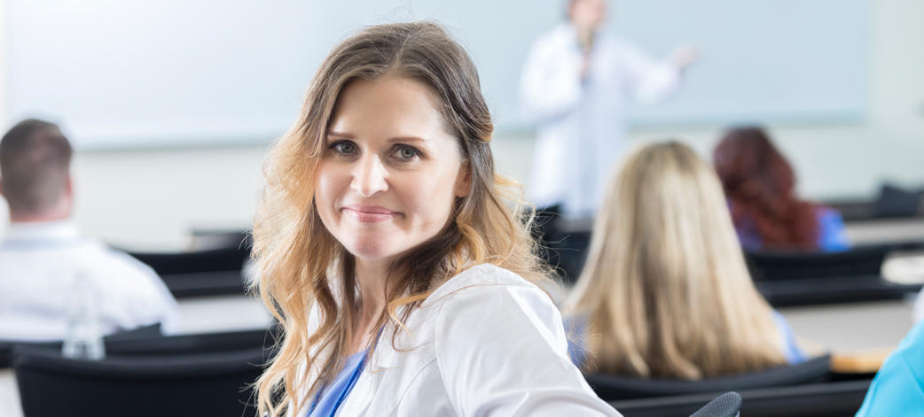 Smiling female med student attends research seminar