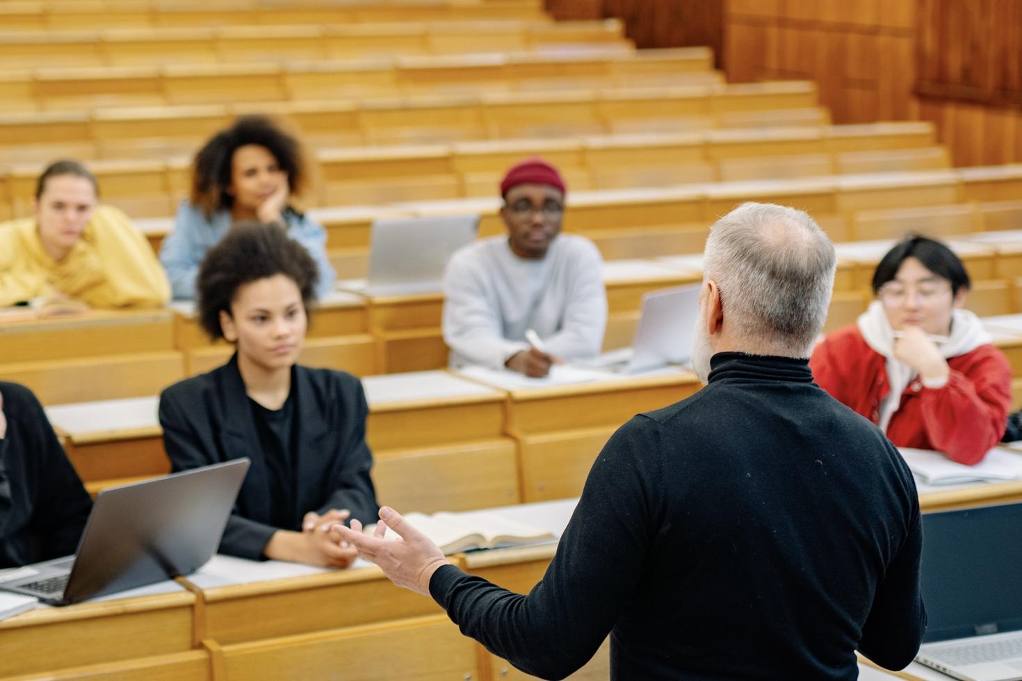 Speaker addressing participants in a lecture hall during an educational or professional training session.