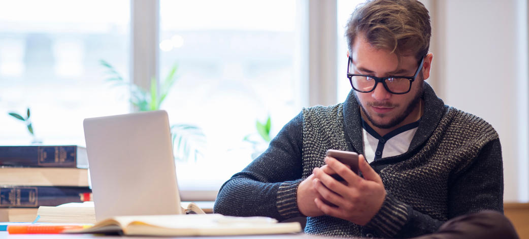 Guy using smartphone and laptop
