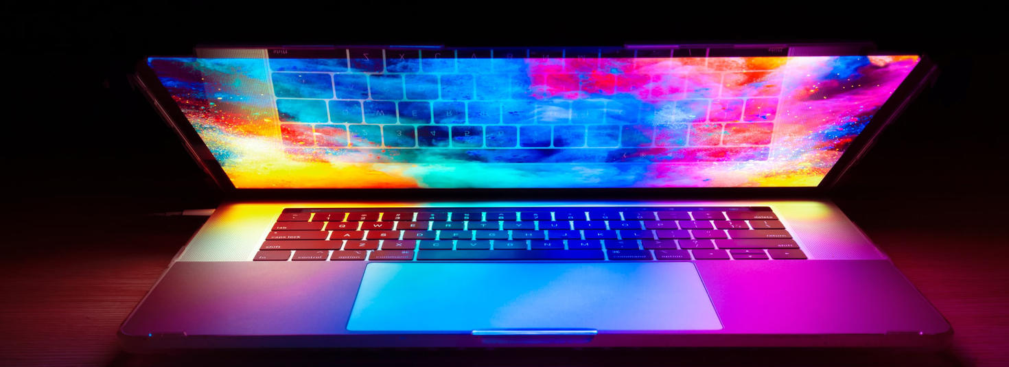 Laptop half closed with multicolor light reflections.