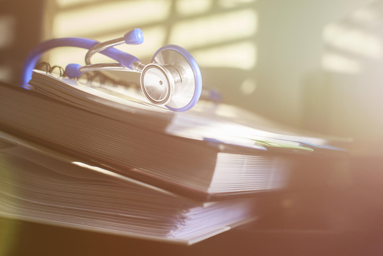 stethoscope on stack of medical guide book