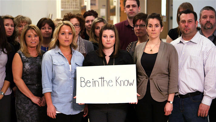 Support staff holding a sign: Be in the know