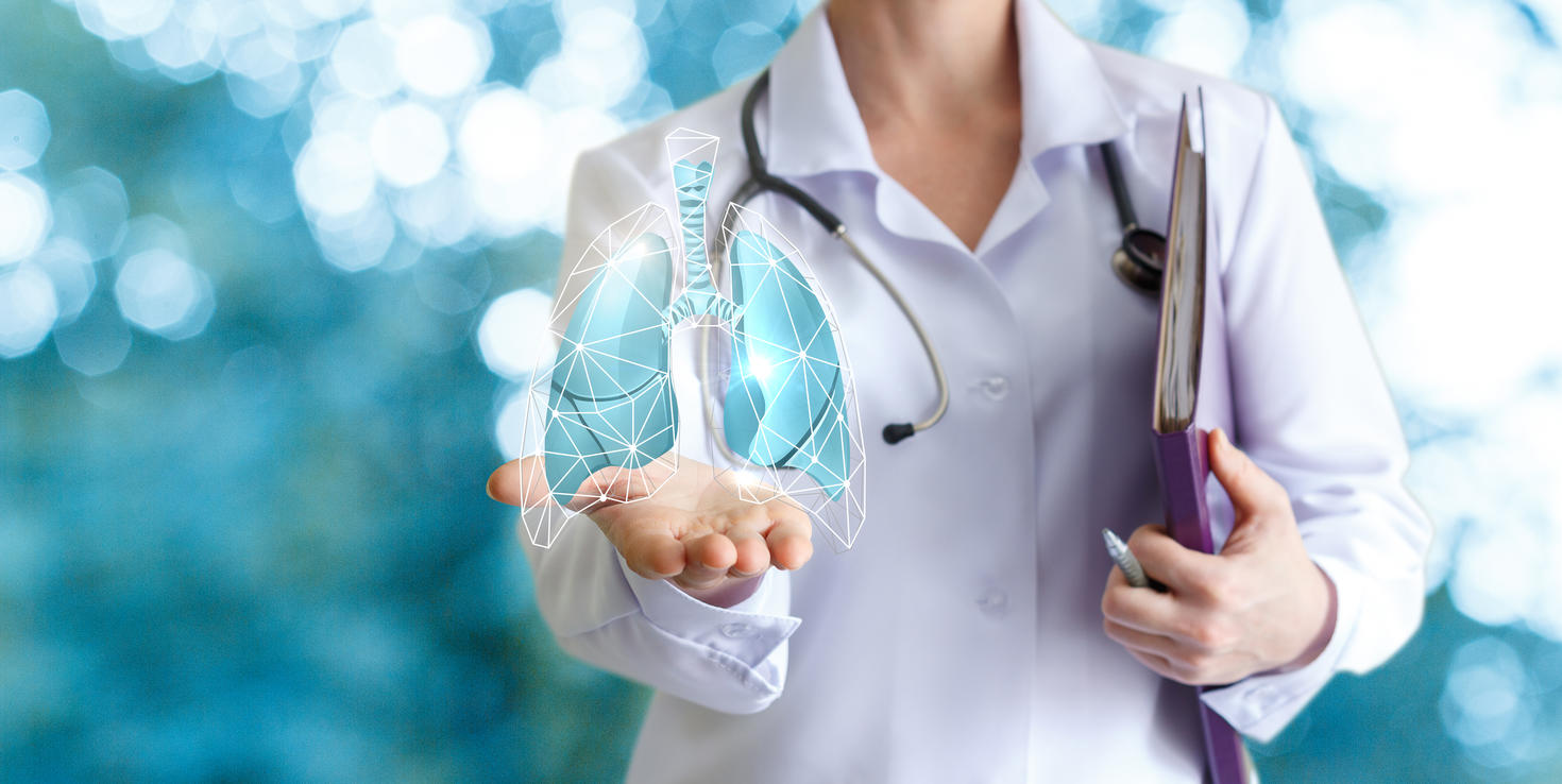 Médecin montre des poumons humains sur fond flou.