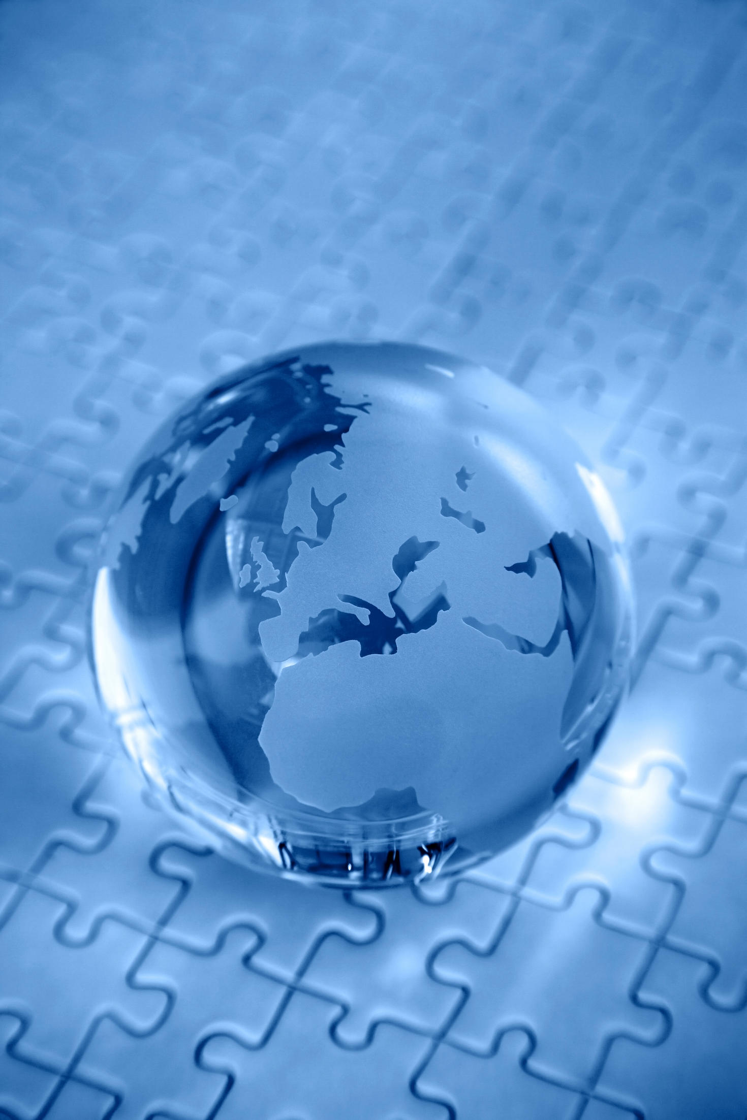 Blue glass globe on jigsaw puzzle background