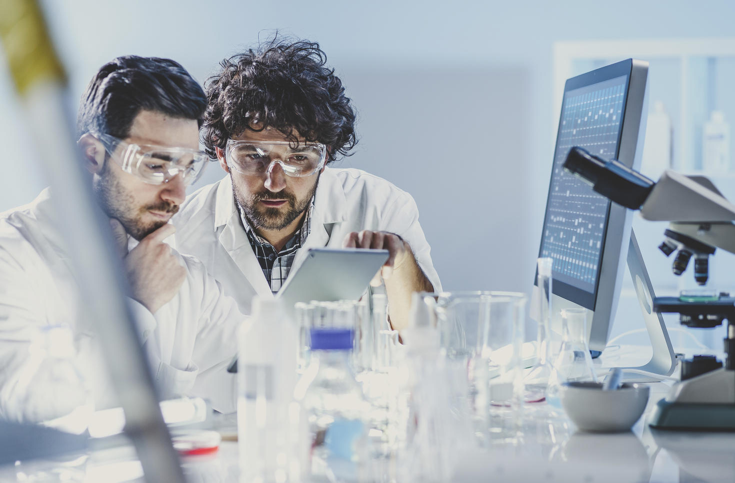 Two male scientists reviewing results on a tablet