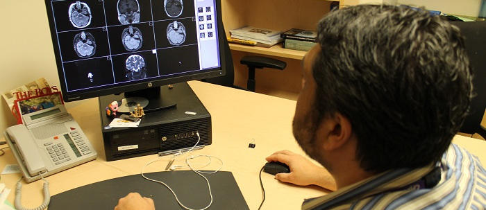A physician examining photos of the brain