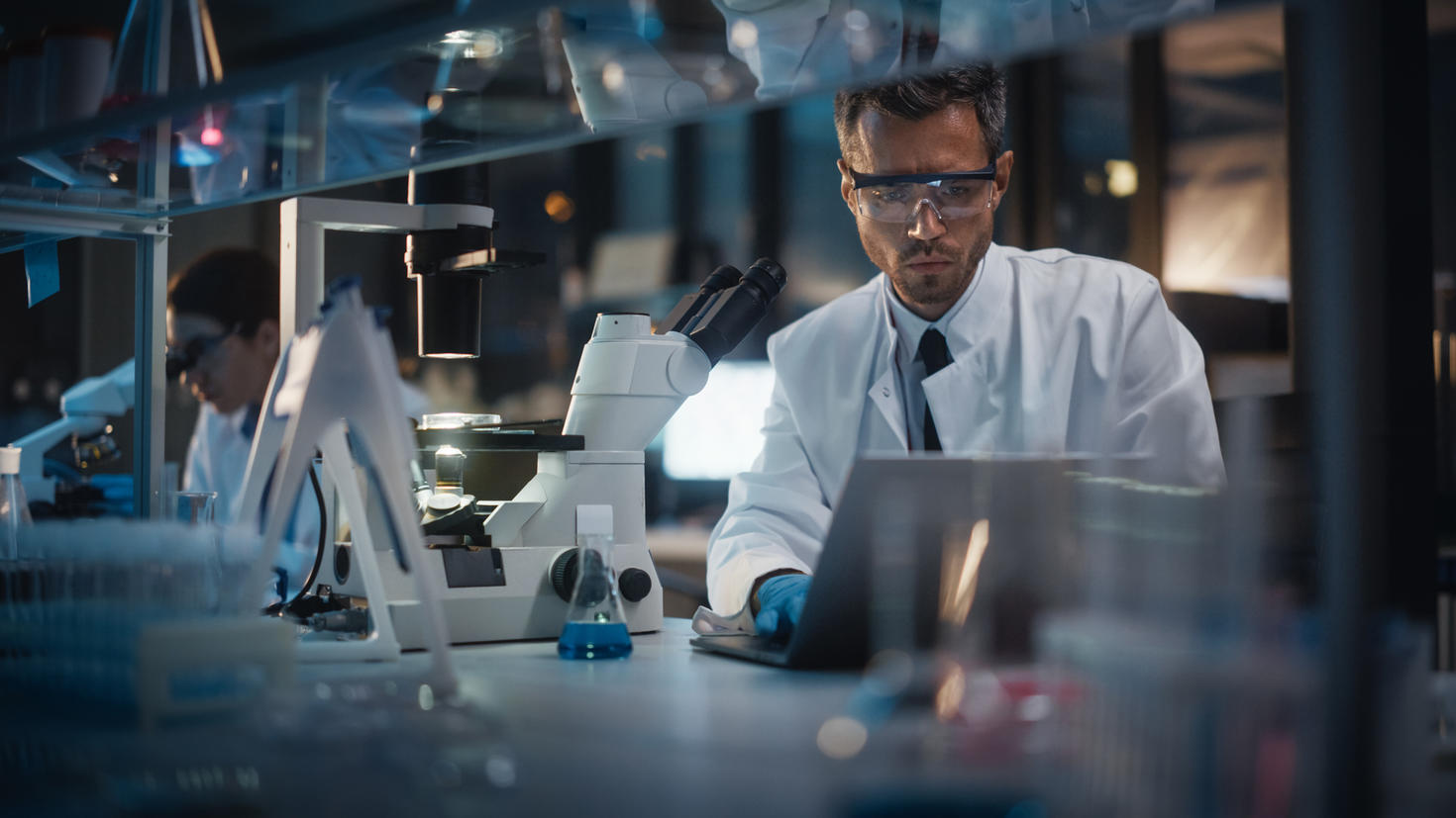male researcher doing research on laptop in lab